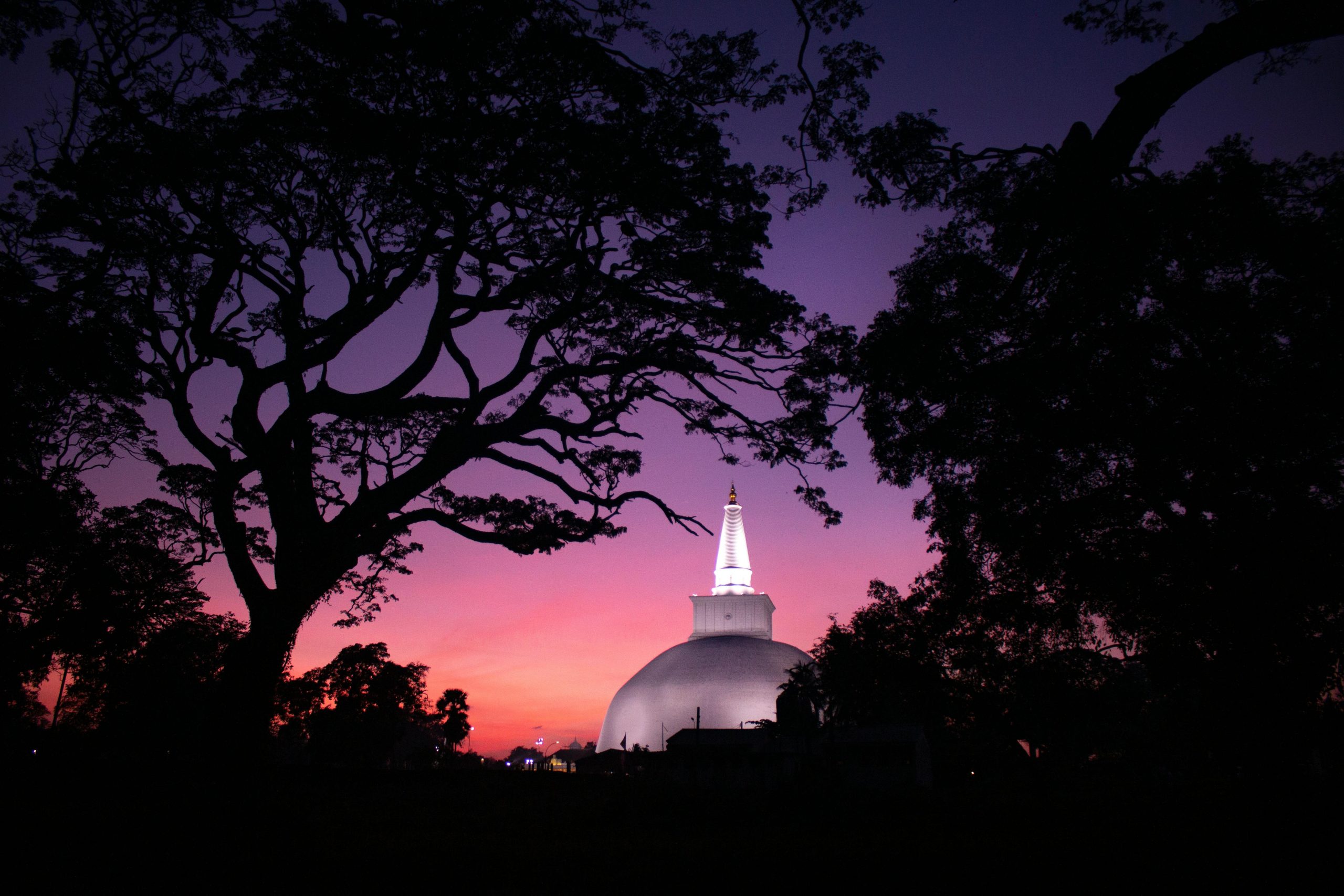 Stunning view of the Ruwanweli Maha Seya stupa against a vibrant twilight sky in Anuradhapura, Sri Lanka.
